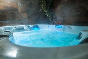 un jacuzzi con agua azul. en Haven Spa Luxury Loft - Como City Centre, en Como