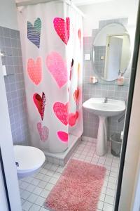 a bathroom with a shower curtain with hearts on it at Doppelroom with Terrace in Därligen