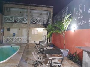 um quarto com uma piscina e cadeiras, uma mesa e uma banheira em Casa L&A 01 em Aracati