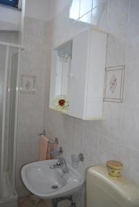 a bathroom with a sink and a toilet and a cabinet at Apartment Rama in Poreč +51 photos