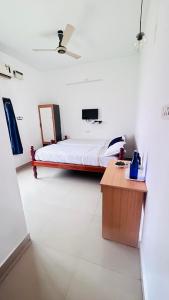 a white room with a bed and a table at Casa De Neel in Puducherry