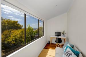 ein Wohnzimmer mit einem großen Fenster und einem Sofa in der Unterkunft Sea Glass Cottages Burnie Tasmania in Burnie