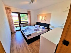 1 dormitorio con cama y ventana grande en Ferienwohnungen Pappenheimer, en Oberlangfurth