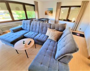 a living room with a blue couch and a table at Ferienwohnungen Pappenheimer in Oberlangfurth