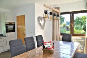 a dining room table with chairs and a heart on the wall at Ferienwohnungen Pappenheimer in Oberlangfurth +12 photos