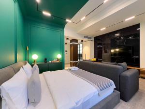 a bedroom with a large bed and a green wall at Bentley Hotel Tashkent in Tashkent