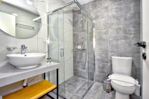 a bathroom with a shower and a toilet and a sink at Georgia's Garden by Omilos Hotels in Amoudara Herakliou