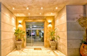 a hallway with potted plants in a lobby at Georgia's Garden by Omilos Hotels in Amoudara Herakliou