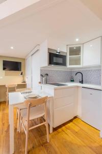 een keuken met witte kasten en een tafel en stoelen bij Charming renovated and bright studio in the center in Lille +17 foto's