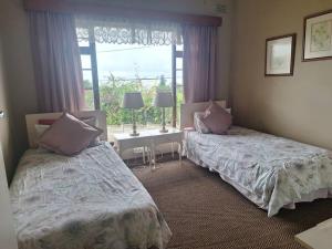 2 Betten in einem Zimmer mit Fenster in der Unterkunft Ukuthula Blissful Breakaways in Margate