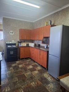eine Küche mit einem weißen Kühlschrank und Holzschränken in der Unterkunft Ukuthula Blissful Breakaways in Margate