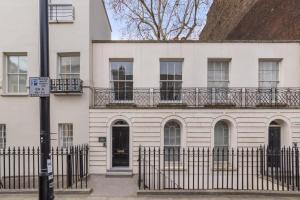 a white building with a balcony on top of it at Regency Residences - Fitzrovia - by Frankie Says in London