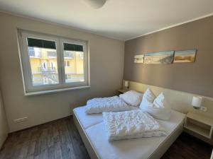 a bedroom with two beds and a window at Küstenbrise 1 in Graal-Müritz