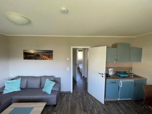 a living room with a couch and a kitchen at Küstenbrise 1 in Graal-Müritz +8 photos
