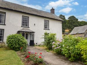 a white house with flowers in front of it at 3 bed in Corwen 86266 in Corwen