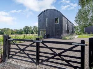 a black barn with a fence in front of it at 3 Bed in Ludlow 83865 in Lane to Richards Castle