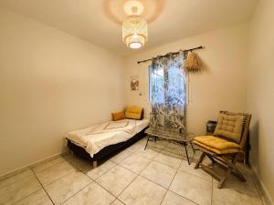 - une chambre avec un lit, une chaise et une fenêtre dans l'établissement VILLA MARILOU climatisée pour 6 personnes avec piscine sur le Domaine de Valcros à la Londes-Les-Maures, à La Londe-les-Maures
