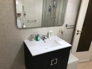 a bathroom with a white sink and a mirror at Busalacchi B&B in Mondello