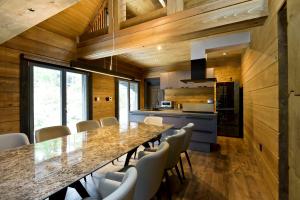 a kitchen with a long table and chairs at Fountainhead Hakuba in Hakuba