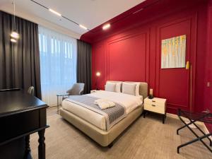 a bedroom with a bed with red walls and a piano at Bentley Hotel Tashkent in Tashkent