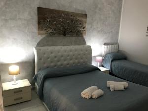 a bedroom with a bed with two towels on it at Busalacchi B&B in Mondello