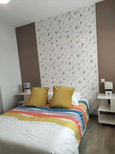 a bedroom with a bed with two yellow pillows at L'Atlantique Appartement en front de mer in Jard-sur-Mer