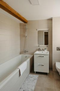 La salle de bains blanche est pourvue d'une baignoire et d'un lavabo. dans l'établissement Holiday Agoston Apartments, à Timişoara