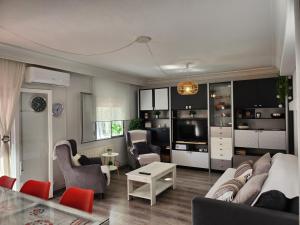 sala de estar con sofá, sillas y TV en Apartamento Madrid dBA3 en Madrid