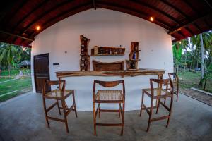 um quarto com uma mesa e quatro cadeiras em Village Paradise em Beliatta