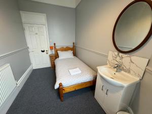 ein Bad mit einem Waschbecken und einem Spiegel in der Unterkunft The Elms Guest House Bristol in Bristol