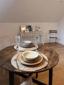 コブレンツにあるApp7 - place2b - direkt am Rheinの皿とワイングラスが置かれた木製のテーブル