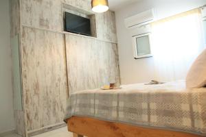 a bedroom with a bed and a tv on a wall at Ionian Balcony in Athanion