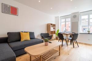 salon z kanapą i stołem w obiekcie Lille center equipped and bright apartment w Lille