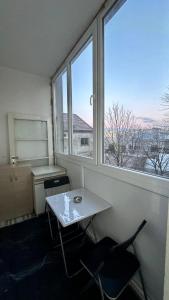 une chambre avec une table, deux chaises et une fenêtre dans l'établissement Apartman Moon, à Belgrade