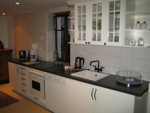 a kitchen with white cabinets and a sink at Im Alten Kaufhaus in Rhodt unter Rietburg