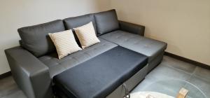 a black couch with two pillows in a room at Apartamentos Entrellusa in Perlora