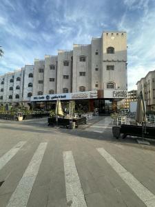 un gran edificio con mesas y sillas delante de él en Dosh Hotel, en Medina