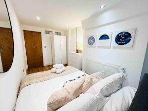 a bedroom with a large white bed with two pillows at Highgate Garden Apartment- 2 Bed in London
