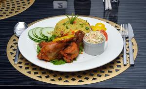 a plate of food with meat and rice on a table at CHILLERS HOTEL AND SUITES in Aiyetoto-Asogun