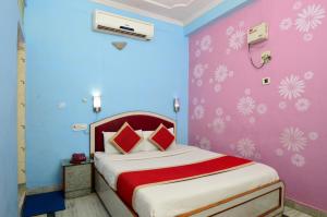 齋浦爾的住宿－HOTEL JAI MAA PALACE，一间卧室配有一张蓝色和粉红色的墙壁。