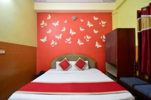 - une chambre avec un lit et un mur rouge aux papillons dans l'établissement HOTEL JAI MAA PALACE, à Jaipur