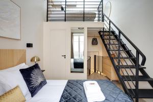 a bedroom with a bed and a spiral staircase at Rénovation Chic Appart 17th Terrace & Mezzanine in Paris