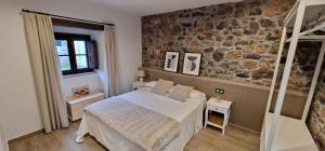 a bedroom with a bed and a stone wall at Apartamentos Entrellusa - AT-1482-AS in Perlora
