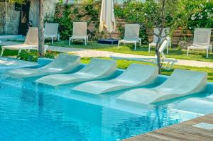 eine Gruppe Stühle und ein Pool in der Unterkunft Georgia's Garden by Omilos Hotels in Ammoudara