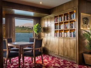 a dining room with a table and chairs and a book shelf at Steigenberger Regency Nile Cruise - Every Saturday from Luxor for 07 & 04 Nights - Every Wednesday From Aswan for 03 Nights in Luxor