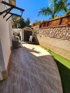 a walkway outside of a house with a stone wall at Kati's Room in Eilat