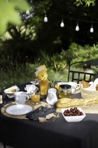 uma mesa com uma toalha de mesa preta com comida em Domaine du Moulin de Villefranche em Pernes-les-Fontaines