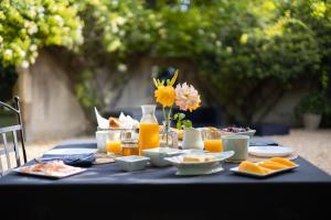 Domaine du Moulin de Villefranche في بيرنيه لو فونتينز: طاولة زرقاء مع طعام وعصير برتقال وزهور