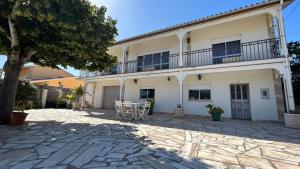 a large white building with a patio and a tree at Casa da Tília in Vale Vazão