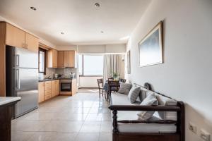 a living room with a couch and a kitchen at Aegean Moments in Glinado Naxos